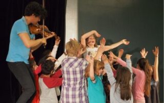 Professioneller Musiker musiziert zusammen mit Kindern